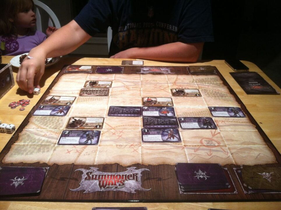 Summoner Wars: Master Set - My friend Sean and I playing Summoner Wars for the first time, while his daughter looks at her father with wonder. He was triumphant.   - Credit: vacekrae