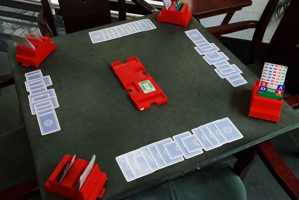 Bridge - This is how tournament tables look after a game ends.  Note that players who have just lost a trick take their card back and place it sideways in front of them, whereas if they win they place the card vertically - this makes it easier to count at the end  - Credit: unicoherent